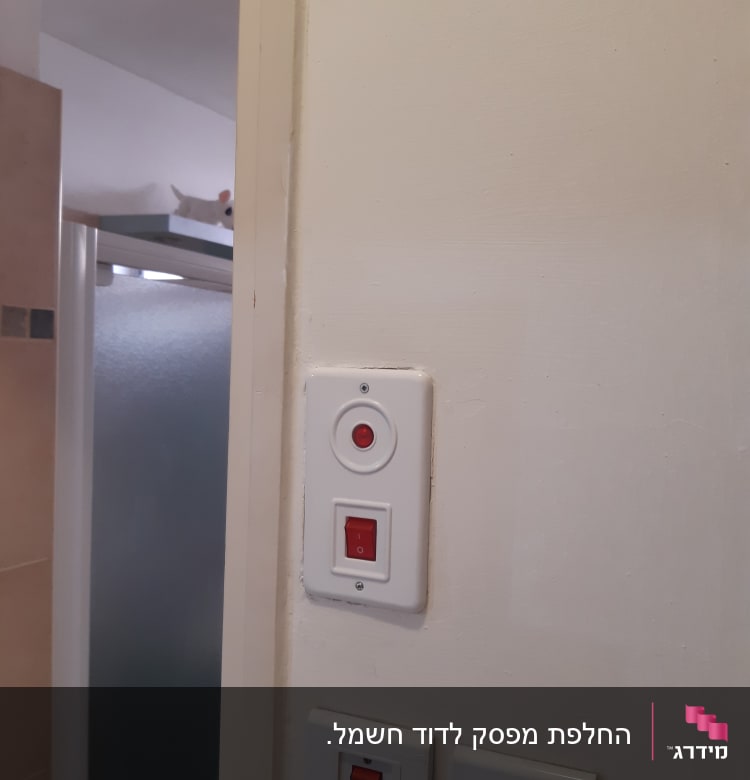 מתגי חשמל על קיר לבן עם כפתור אדום